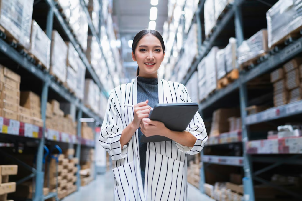 Woman using ecommerce erp system to manage inventory in warehouse.